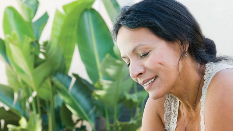 Mature woman reading book on patio lounge chair